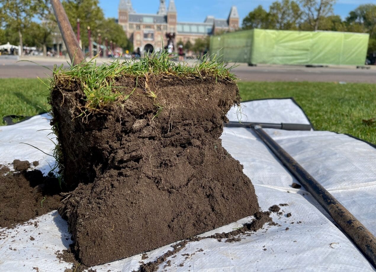 Een stuk met gras en grond, waarop de bodemstructuur te zien is.